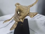 brass turtle sculpture on marble base on marble table top