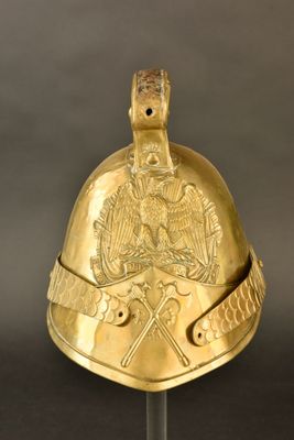 une image représentant un casque doré posé sur un socle, sur fond noir