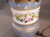 a blue vase with gold trim and flowers on it
