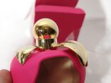 someone is holding a pink perfume bottle in their hand