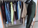 a rack of clothes hanging on a rail in a room