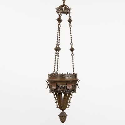 a large brass hanging light fixture with a cross on it