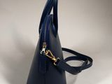 a small blue handbag with a gold zipper on the handle