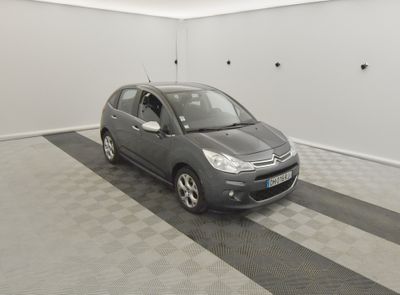 une petite voiture grise garée dans un garage