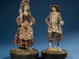 two figurines of a man and a woman dressed in period clothing