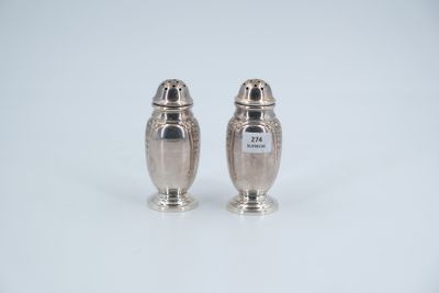 two silver salt and pepper shakers on a white surface