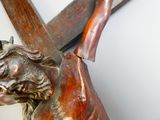 a statue of a man holding a cross and a knife