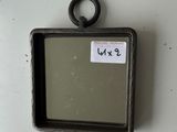 a small mirror hanging on the wall with a tag on it