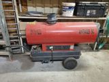 a red gas heater sitting on a cart in a garage