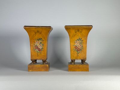 une paire de vases jaunes décorés de fleurs, posés sur une table