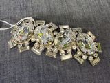 Gros plan sur un bracelet en argent et cristal posé sur une surface grise