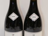 deux bouteilles de vin rouge posées l'une à côté de l'autre sur une table