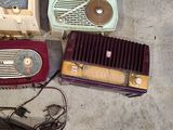 many old radio ' s and other items on the floor