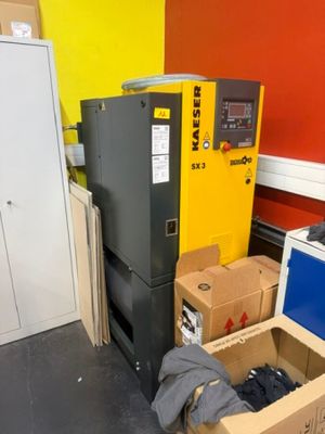 une pièce avec plein de cartons et un réfrigérateur