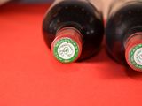two bottles of wine sitting on a red table