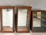 three glass display cases sitting next to each other on a table