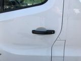 a close up of a car door handle with a dog in the background