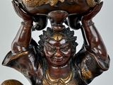 a statue of a woman holding a bowl on her head