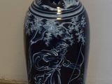 un vase bleu entouré d'une corde, posé par terre