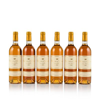 four bottles of wine are lined up on a white surface