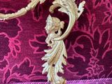 a gold metal hook on a purple fabric covered chair