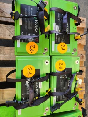 une pile de piles vertes posée sur une palette en bois