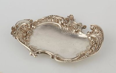 an antique silver plate with a decorative design on it