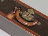 une valise marron sur laquelle est posé un cadenas