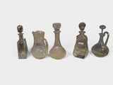 several glass vases and bottles are lined up on a white surface