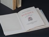 un livre ouvert sur une table, à côté d'une pile de livres