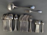 un grand nombre de cuillères et de fourchettes en argent disposées sur une table
