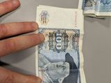 a hand that is holding some money on a table