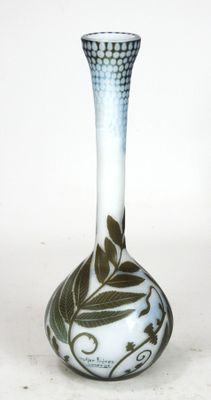 a white and blue vase with green leaves on it