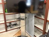 un grand téléviseur à écran plat posé sur un meuble dans un coin de la pièce