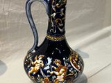 a blue and gold vase sitting on a white table