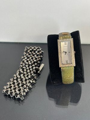 two watches and a bracelet on a black table