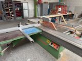 a machine that is cutting a piece of wood in a workshop