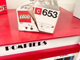 two boxes of legos sitting on top of a red table