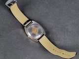 an image of a watch with a yellow strap on a gray surface