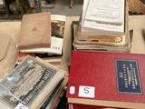many books stacked on top of each other on a table