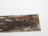 an old rusted piece of metal sitting on top of a white surface