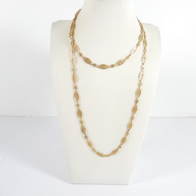 un gros plan sur un mannequin portant un collier à chaîne en or