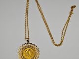 un collier en or avec une pièce de monnaie sur une chaîne