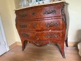 a marble top chest of drawers in the corner of a room