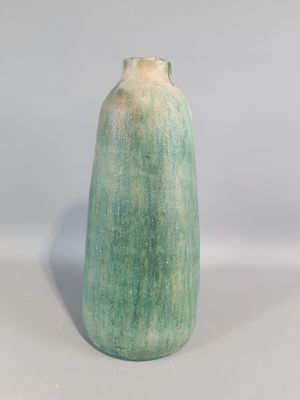 a green vase sitting on top of a white table