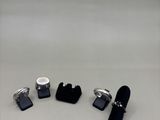 three pairs of black and white cufflinks and a pair of black and white cufflinks