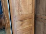 a tall wooden door in a room with a blue chair