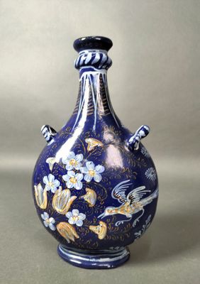 un vase bleu orné d'un motif, posé sur une table