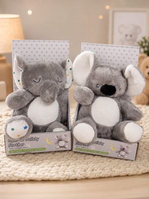 two stuffed animals are sitting in a box on a bed