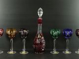 Plusieurs verres à vin et une carafe sont alignés sur une table